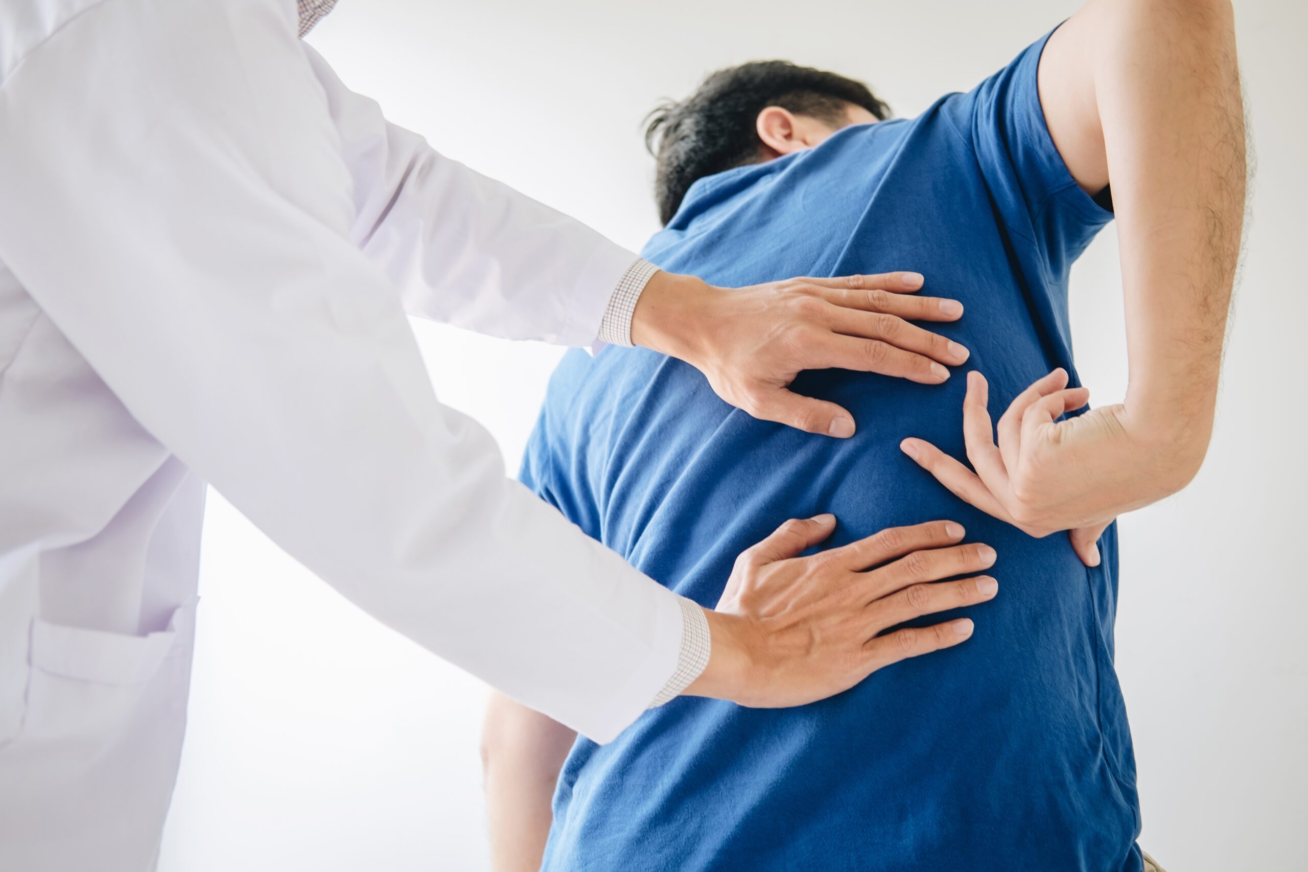 Doctor physiotherapist treating lower back pain patient after wh